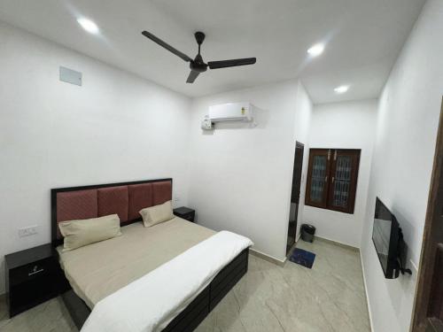 a bedroom with a bed and a ceiling fan at Divine Kashi Near Shree Kashi Vishwanath Temple in Varanasi