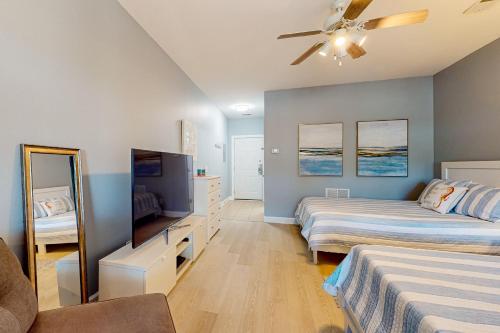a bedroom with two beds and a flat screen tv at Sea Trail Golf-Beach Mini Suite in Sunset Beach
