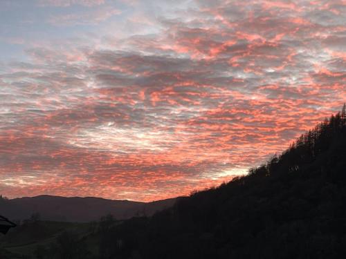 a sky with a sunset in the mountains at The Shepherd's Nook in Thirlmere