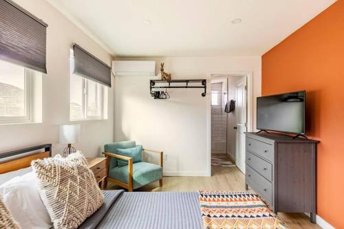 a bedroom with a bed and a tv and a chair at Desert Escape Climbing Wall, Hammocks & Hot Tub15 Min to Joshua Tree Park in Joshua Tree