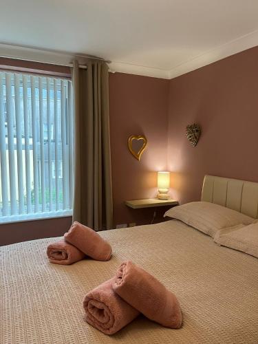 two beds with towels on them in a bedroom at Honey Cottage in Pembrokeshire