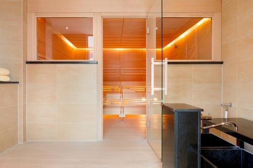 y baño con ducha a ras de suelo y puerta de cristal. en Hotel Stadt Freiburg en Friburgo de Brisgovia