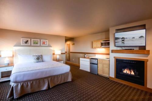a hotel room with a bed and a fireplace at The Ocean Lodge in Cannon Beach