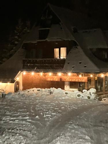 a building covered in snow at night with lights at Mała Bawaria in Zakopane