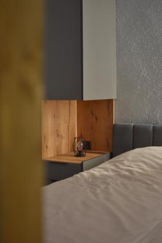 a bedroom with a bed and a table with a clock on it at L 25 Apartments in Bitola