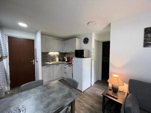 une cuisine avec un réfrigérateur blanc et une table dans l'établissement Résidence Couderes - APPARTEMENT 4 PERSONNES A DEUX PAS DU CENTRE MAE-4764, à Saint-Lary-Soulan