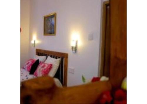 a bedroom with a bed with pink pillows and a mirror at Ivory Safari Lodge in Udawalawe