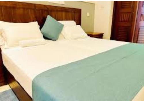 a bedroom with a large bed with white and blue sheets at Ivory Safari Lodge in Udawalawe