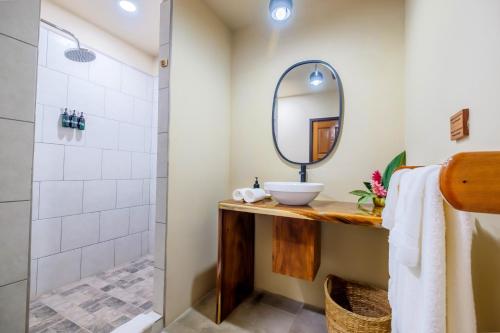 a bathroom with a sink and a mirror at Sweet Songs Jungle Lodge in San Ignacio