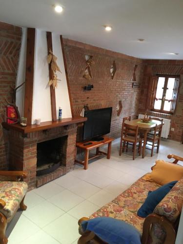 a living room with a fireplace and a tv at La Calleja de Ucieda Balcon in Ucieda de Arriba
