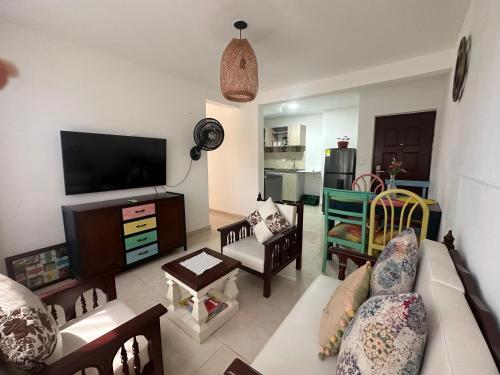 Una sala de estar con un sofá y un televisor de pantalla plana. en Santa Marta Ciudad Dos Veces Santa, en Santa Marta