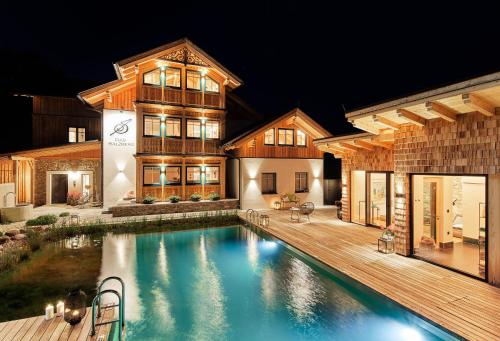 a house with a swimming pool in front of a house at DAS SALZBERG Hideaway Bad Aussee - Adults only in Bad Aussee