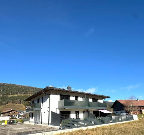 a white building with a hill in the background at Alpin Apartments in Radstadt