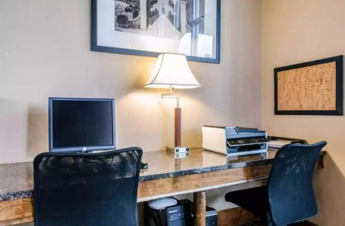 a desk with a laptop computer and a printer at Precious Hotel in Carthage