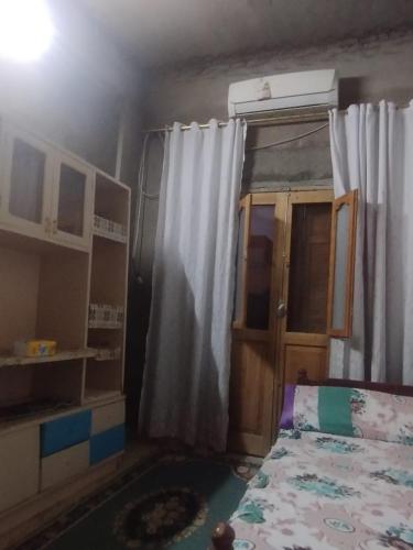 a small bedroom with a bed and a curtain at Ashraf Hostel Guest house in Aswan