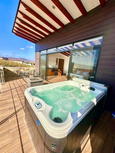 a jacuzzi tub on a deck of a house at Siempre Valle Hotel Boutique in Valle de Guadalupe
