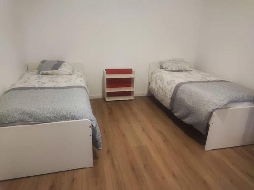 une chambre avec deux lits et un parquet dans l'établissement maison individuelle, à Villenave-dʼOrnon