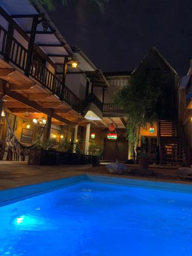 a blue swimming pool in front of a house at night at Casa frente al mar playa Chicama, Puerto Malabrigo in Puerto Chicama