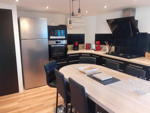 een keuken met een grote houten tafel en een koelkast bij L'estive gîte 4 étoiles in Nasbinals