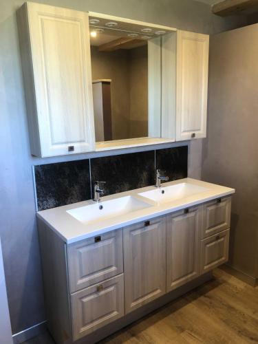 une salle de bain avec deux lavabos et un miroir dans l'établissement L'estive gîte 4 étoiles, à Nasbinals