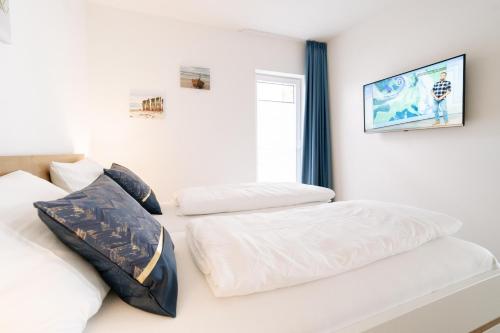 a bedroom with two white beds and a window at Nordsee Oase 50 0 N in Wangerland