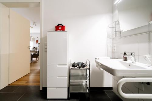 a white bathroom with a sink and a mirror at Nordsee Oase 50 0 N in Wangerland