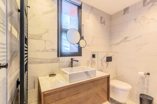 une salle de bain avec un lavabo, des toilettes et un miroir dans l'établissement Résidence Les Cristaux - CRISTAUX B12 MAE-0241, à Arc 1800