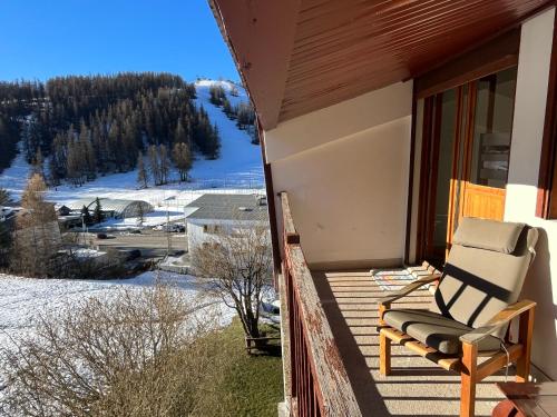 a chair sitting on a porch with a view of a mountain at Valberg 3 pièces au pied des pistes in Péone