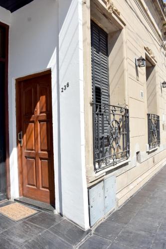 a building with a wooden door and a balcony at Las Blanquitas- departamento en el centro de Chascomús, a pocos metros de la laguna in Chascomús