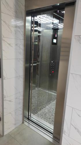 a glass shower in a bathroom with white tile at Нові Loft Апартаменти 5 (центр-залізничний вокзал) in Ivano-Frankivsʼk