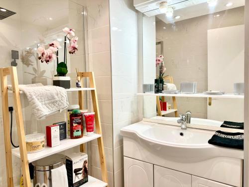 une salle de bain blanche avec un lavabo et un miroir dans l'établissement Le GALLIA 2 BEDROOM refait à neuf CENTER OF CANNES, à Cannes
