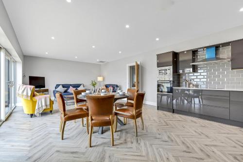 a kitchen and dining room with a table and chairs at BayView Luxury 3 Bedroom Apartment First Floor in Downings