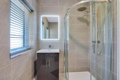 a bathroom with a shower and a sink and a mirror at BayView Luxury 4 Bedroom Penthouse in Downings