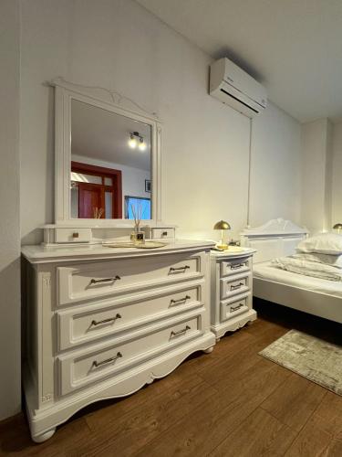 a bathroom with a white dresser and a mirror at Pensiunea Pictorilor in Baia Mare