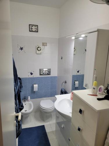 a bathroom with a white toilet and a sink at Casa Orchidea in Castelsardo
