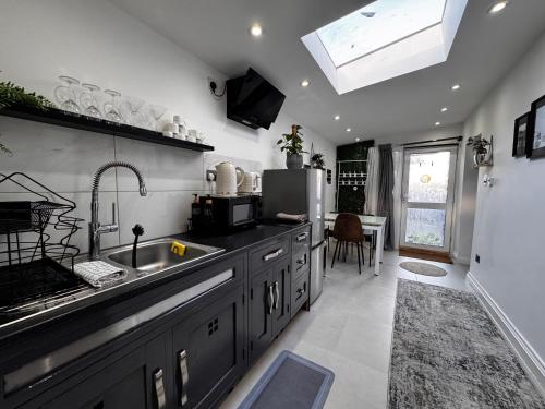 a kitchen with a sink and a refrigerator at Modern One Bedroom Flat in Twickenham for Business Travelers in Hanworth