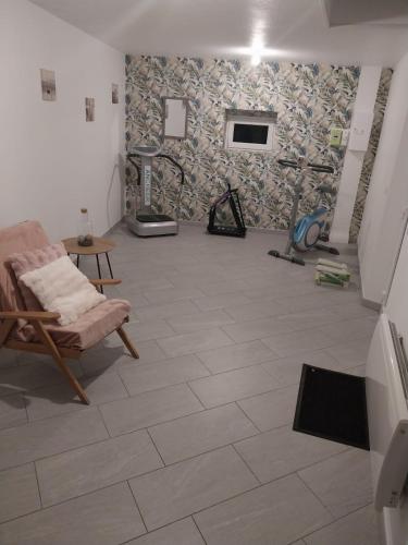 a room with a tile floor with a chair and a fireplace at Le murmure du ruisseau - Pièce de vie 60 m2 - Terrasse 30 M2 - 2 WC in Sémeries