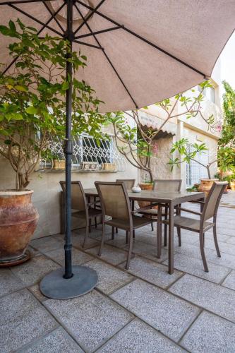 a table and chairs under an umbrella on a patio at Guest house Ashdod-beach in Ashdod