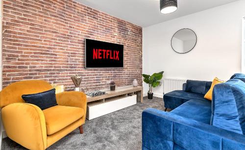 a living room with two blue chairs and a brick wall at Stunning Two Bedroom-Free Parking-Central Location-Two Bathrooms-Close to Airport & Station in Luton