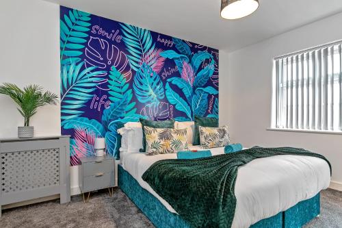 a bedroom with a bed with a tropical mural on the wall at Stunning Two Bedroom-Free Parking-Central Location-Two Bathrooms-Close to Airport & Station in Luton