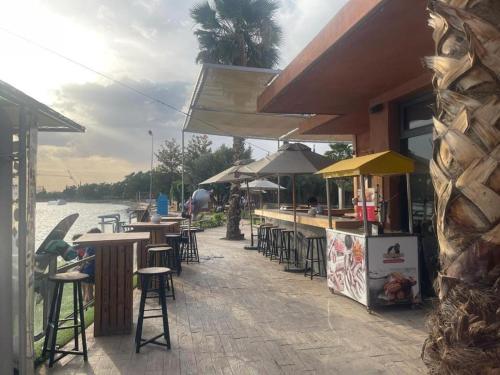 a bar with tables and chairs next to the water at appart jardin de l atlas Marrakech Waky Beach Golf Montagne de l Atlas in Marrakech