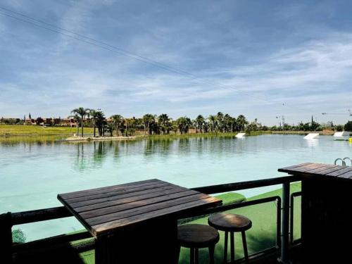 a view of a river with a table and two stools at appart jardin de l atlas Marrakech Waky Beach Golf Montagne de l Atlas in Marrakech