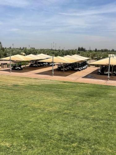 a group of buildings with yellow roofs and a grass field at appart jardin de l atlas Marrakech Waky Beach Golf Montagne de l Atlas in Marrakech