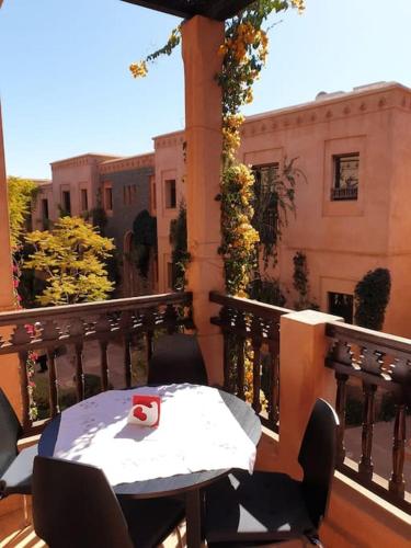 a table and chairs on a balcony with a building at appart jardin de l atlas Marrakech Waky Beach Golf Montagne de l Atlas in Marrakech