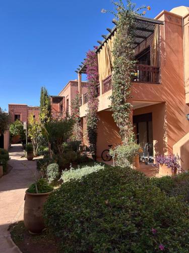 a building with flowers on the side of it at appart jardin de l atlas Marrakech Waky Beach Golf Montagne de l Atlas in Marrakech