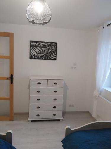 a bedroom with a dresser and a clock on the wall at Le murmure du ruisseau - Pièce de vie 60 m2 - Terrasse 30 M2 - 2 WC in Sémeries