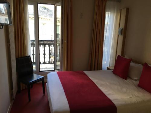 Cette chambre d'hôtel comprend un lit, une chaise et un balcon. dans l'établissement Hotel Antin St Georges, à Paris