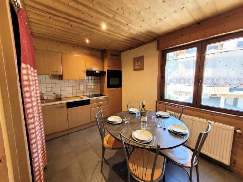 une cuisine avec une table et des chaises dans une pièce dans l'établissement Résidence Beau Sejour - Testez le confort de louer un appartement à deux pas des remontées mécaniques ! MAE-7551, aux Gets