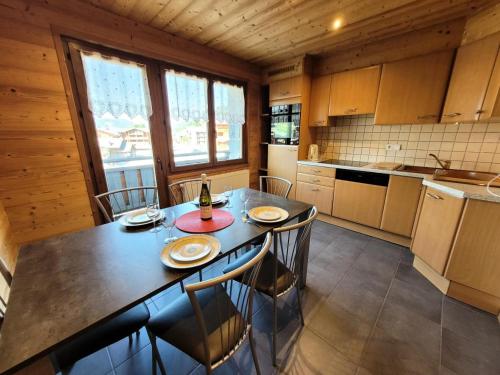 une cuisine avec une table et des chaises dans une pièce dans l'établissement Résidence Beau Sejour - Appartement avec vue dégagée, situation idéale MAE-7571, aux Gets
