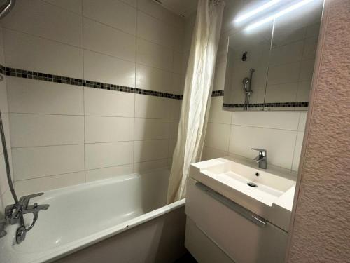 une salle de bain avec un lavabo et une baignoire et un lavabo dans l'établissement Residence 3000 Bail - Studio pour 4 Personnes 12, à Mâcot La Plagne